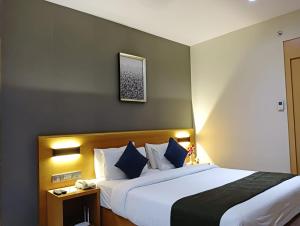 巴罗达Hotel Suba Elite Vadodara的酒店客房配有一张带蓝色枕头的大床