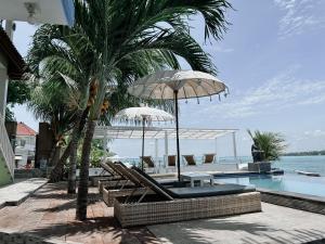 蓝梦岛极光海滩景旅馆的毗邻度假酒店的带椅子和遮阳伞的游泳池