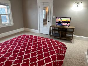明尼阿波利斯The Uptown Oasis的一间卧室配有红色的床和电视。