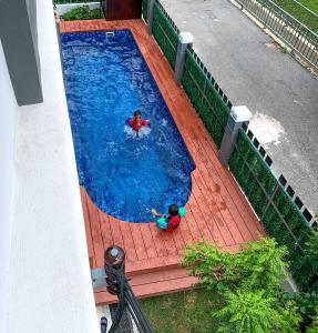 Tangga BatuA home with private pool, Kebun Kecil的两个孩子在大型游泳池玩耍
