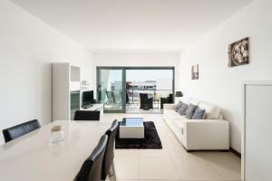拉戈斯Marina Village Apartment的白色的客厅配有桌子和沙发