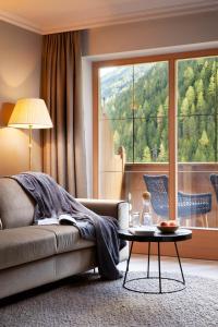 图克斯Adler Inn Tyrol Mountain Resort SUPERIOR的带沙发和桌子的客厅以及大窗户。