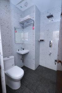 斯里卡拉哈斯蒂Hotel Vijaya Grand的浴室配有白色卫生间和盥洗盆。