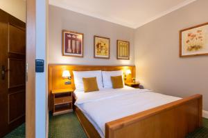 瓦拉什斯凯梅济日奇埃伯基康体酒店的一间卧室配有一张带白色床单和两盏灯的床。
