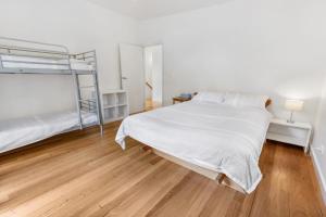 Lake TyersFlounder的一间卧室设有两张双层床,铺有木地板。