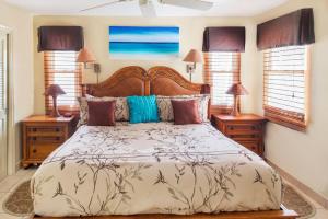 格雷斯湾珊瑚花园格雷斯湾度假村的一间卧室设有一张大床和两个床头柜