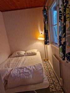 UndenäsUtsikt mot viken的一间卧室配有床、灯和窗户