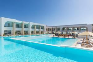 沙姆沙伊赫White Hills Resort的一座大型游泳池旁设有椅子和遮阳伞
