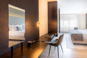 马斯特里赫特Select Hotel Maastricht的酒店客房配有一张床和一张带镜子的书桌