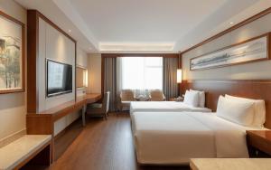 南京南京新街口王府大街亚朵酒店的酒店客房设有两张床和电视。