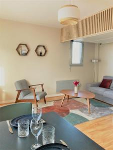 多维尔Studio proche plage balcon et parking的客厅配有桌子和沙发