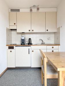 KrattigenEva's Seeblick的厨房配有白色橱柜和木桌