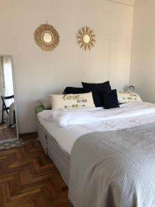 维森特洛佩斯Departamento En Vicente Lopez的一间卧室配有带白色床单和枕头的床。