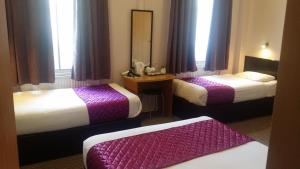伦敦阿里瓦酒店的酒店客房,设有两张床和镜子
