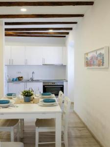 茨雷斯Apartments Blue Lavender的白色的厨房配有白色的桌子和椅子