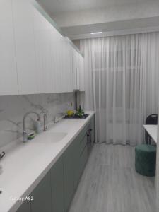 苏姆盖特Luxury Guest House的厨房配有白色橱柜和白色台面