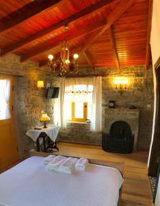 格克切达镇SARI KEÇİ TAŞ OTEL的一间卧室配有一张床和一个壁炉