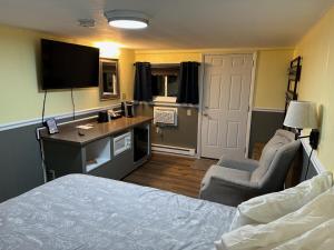圣伊尼亚斯圣伊格内斯日落汽车旅馆的一间卧室配有一张床、一张书桌和一台电视。