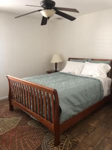 圣奥古斯丁Modern, Upscale, and New Blue Bungalow in the heart of Downtown St Augustine的一间卧室配有一张带吊扇的床