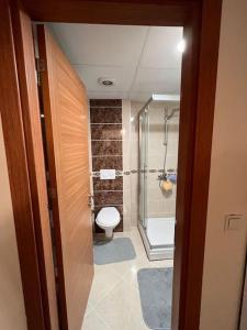 厄森尤特Luxury 1+1 in Istanbul的一间带卫生间和玻璃淋浴间的浴室