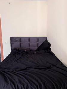 厄森尤特Luxury 1+1 in Istanbul的一张带黑色棉被和两个枕头的床