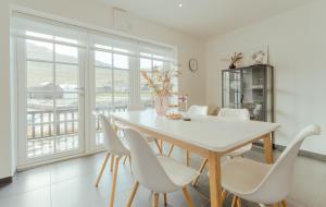 LeirvíkNew Boat House的一间设有白色桌子和白色椅子的用餐室