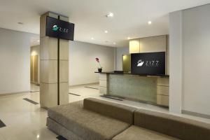 登巴萨吉兹会议酒店的大堂配有沙发和墙上的电视