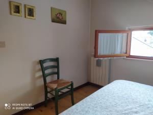 奥温多利Appartamento Bucaneve的一间卧室配有椅子、床和窗户