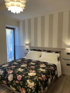 佩鲁贾Atelier Fuori Città的一间卧室配有一张带花卉图案的毯子的大床
