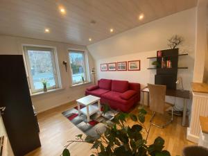 吕贝克Ferienwohnung Maike的客厅配有红色的沙发和桌子