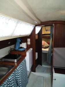 Nonsardnuit sur un voilier的小房间设有书桌和一张位于货车内的床铺