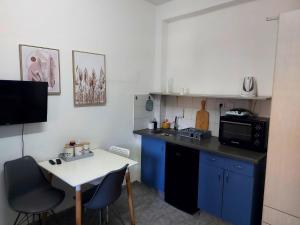 拉马特甘Studio 91 By IsrApart的小厨房配有白色桌子和蓝色橱柜