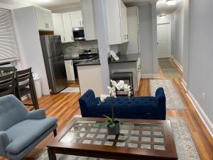 波士顿Spacious Apartment in Boston的一间带蓝色沙发的客厅和一间厨房
