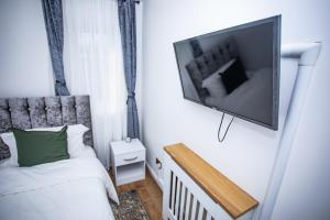Thamesmeadla vida in casa的卧室配有一张床和壁挂式平面电视。
