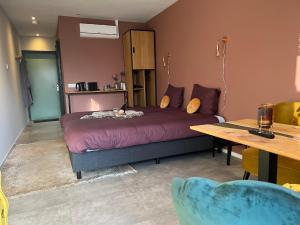 BlesdijkeNatuur lodge的一间卧室配有一张大床、一张桌子和一张桌子。