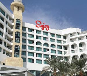恩波其克Enjoy Dead Sea Hotel -Formerly Daniel的一间大型酒店,旁边有一个标志
