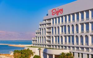 恩波其克Enjoy Dead Sea Hotel的一座在海边有索尼标志的建筑