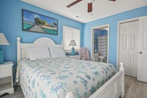 默特尔比奇Lighthouse II Unit 6的卧室配有白色的床和蓝色的墙壁