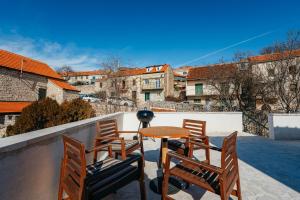 伊莫茨基BOUTIQUE APARTMENTS IMOTSKI, Imotski - Makarska的阳台的天井配有桌椅