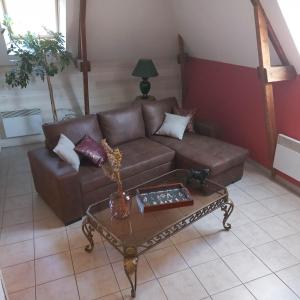 蓬托尔松Les Fauvettes的客厅配有棕色沙发和茶几