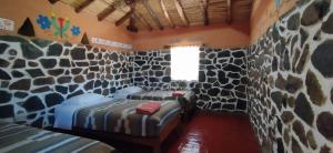 CoporaqueLodge Mirador San Antonio- Colca的一间设有两张位于岩石墙内床的房间