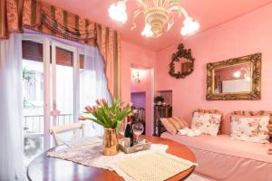 阿雷佐BIBI BOUTIQUE AREZZO Appartamento Rosafragola - Verdeconiglio的粉红色的客厅配有桌子和沙发