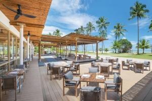 蔻立JW Marriott Khao Lak Resort and Spa的一个带桌椅的户外庭院,棕榈树