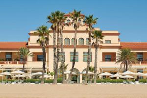 埃勒凡达尔艾美海滩水疗酒店的一座棕榈树环绕的大建筑