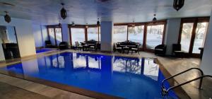 科法德比安Faqra Palace的一个带桌椅的房间的大型游泳池