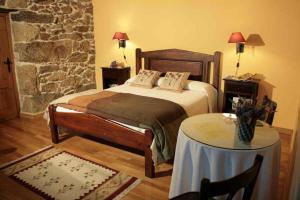 Rairiz de Veiga卡萨瑞克托拉康达旅馆的卧室配有一张床和一张桌子