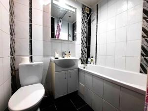 波尔塔瓦Один каштан Мережа Alex Apartments Безконтактне заселення 24-7的白色的浴室设有卫生间和水槽。