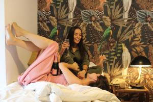 塔尔卡Hotel Marcos Gamero的两个女人坐在床上,腿放在空中