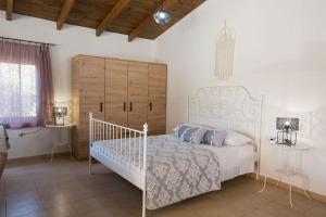 阿凡杜Serenity Studio Beach Home的卧室配有白色的床和木制床头板