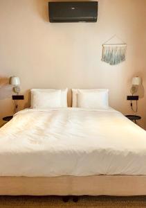 马拉加Casita 10 Málaga, holiday home with roof terrace的一张白色大床,配有白色床单和枕头